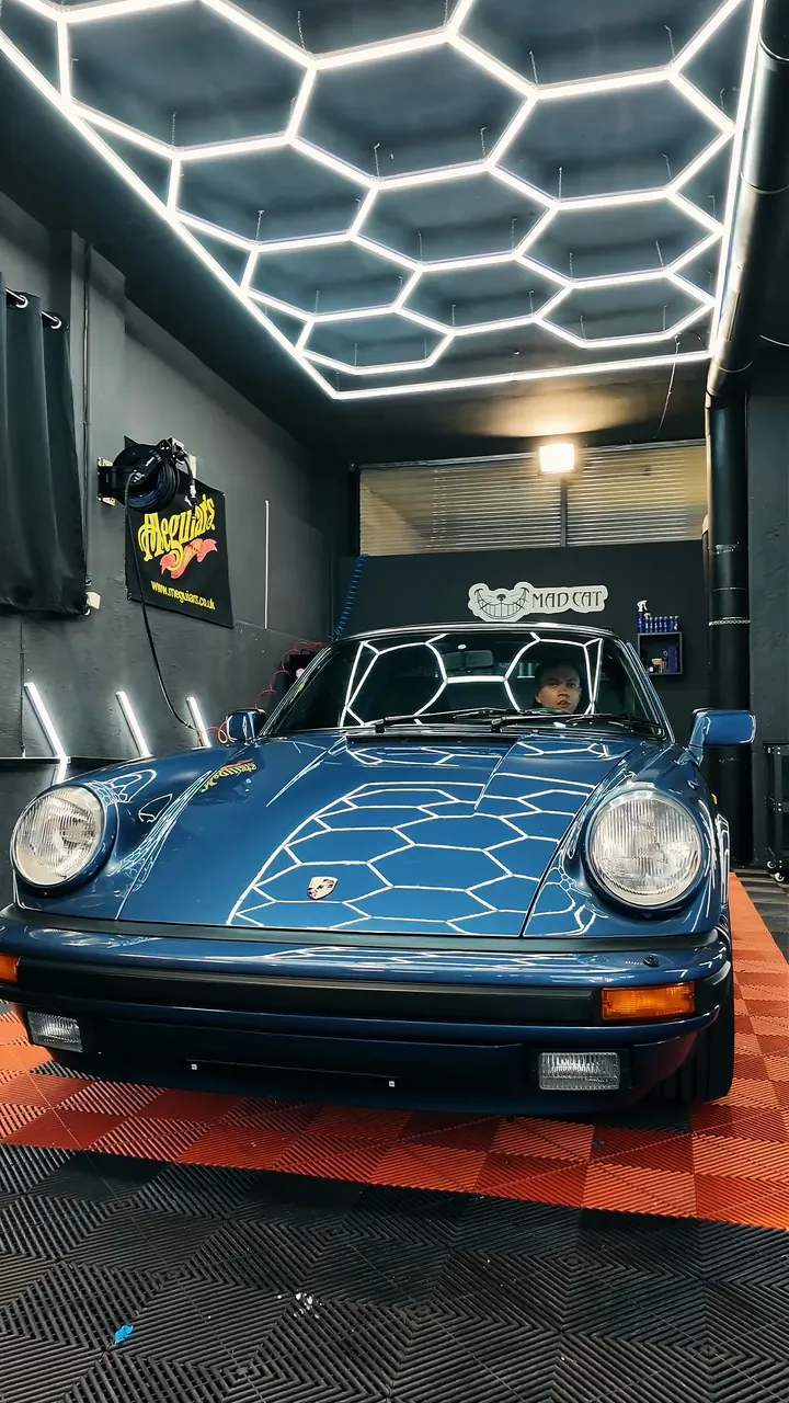 Blauer Porsche 911 unter dem Hexagon-Licht in der Werkstatt von Mad Cat Detailing in Palling